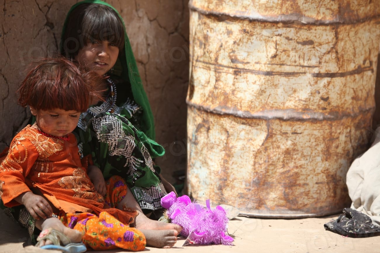 Afghan child sits with her